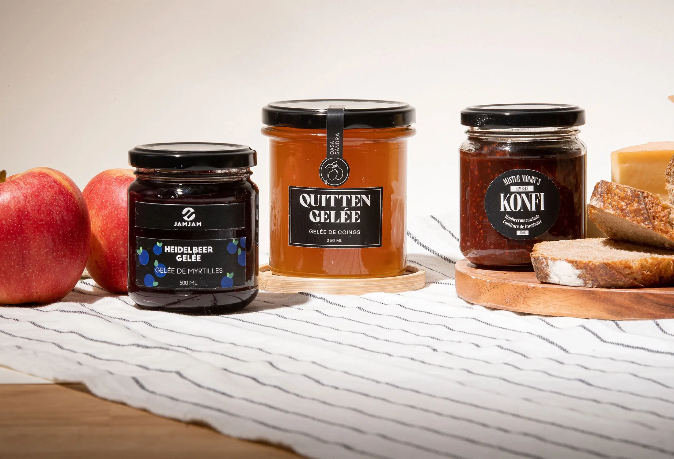 Konfitüren- und Geléegläser von Müller+Krempel – 205 ml Konfitürenglas hoch TO-58 und 350 ml Sturzglas TO-82 mit schwarzem Deckel, befüllt mit Heidelbeer-Gelée, Quitten-Gelée und Frucht-Konfi